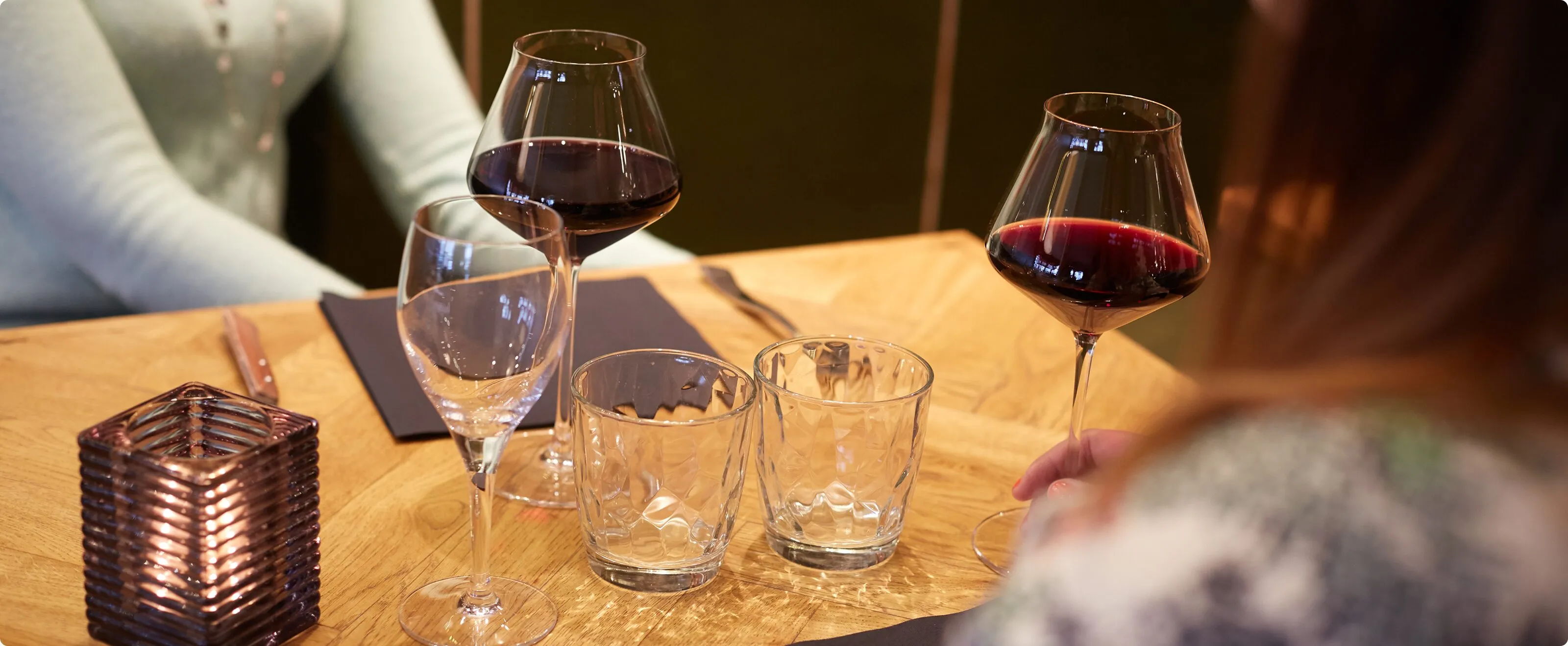 Convives attablés autour d’un verre de vin dans la salle du bistrot